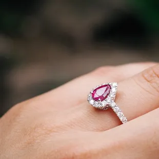 Pear-shaped ruby with a halo of diamonds.