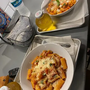 two bowls of pasta on a tray