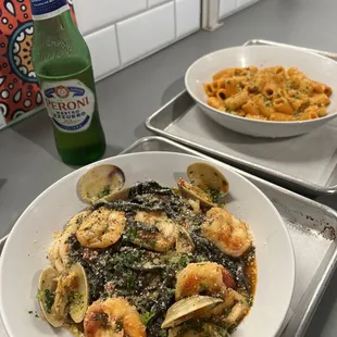 two bowls of pasta and a bottle of beer