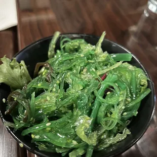 a bowl of green vegetables on a table
