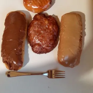 Two custard filled long johns, an apple fritter, and blueberry filled donut from Bosa Donuts. Long Johns were delicious