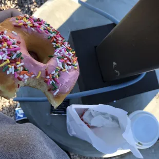 a person holding a donut with sprinkles