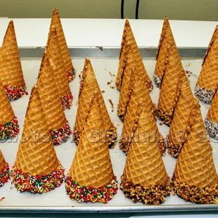 a tray of ice cream cones with sprinkles