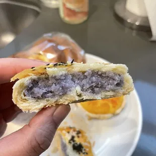 a hand holding a half eaten pastry