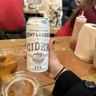 a person holding a can of beer