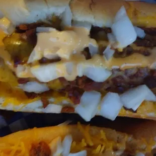 two hot dogs with cheese and onions