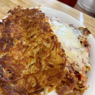 Bacon, cheese, and tomato omelet with crispy hash browns