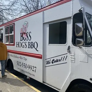 a man standing next to a bbq truck