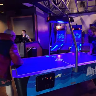 two men playing air hockey