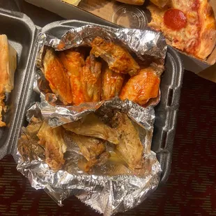 a tray of chicken wings, pizza, and hot dogs