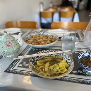 a bowl of noodles and a teapot