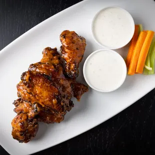 a platter of chicken wings, carrots, celery, and ranch dressing