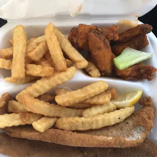 a sandwich and fries in a styrofoam container