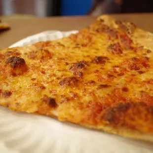 a slice of cheese pizza on a paper plate