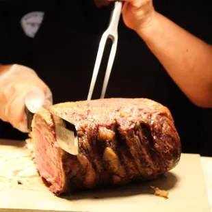 a person cutting a piece of meat