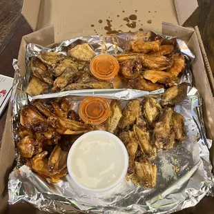 Bucket of Wings with four sauces: garlic parmesan, medium, lemon pepper, and sweet baby chili.