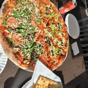 a hand holding a slice of pizza