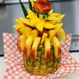 a pineapple topped with sliced fruit