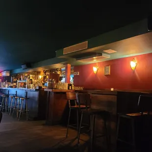 a bar with stools and tables