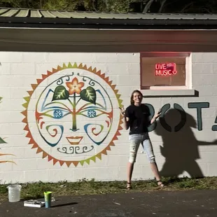 a woman standing in front of a mural