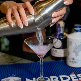 a bartender pouring a martini