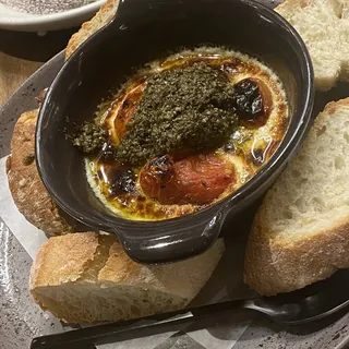 GOAT CHEESE DIP Goat cheese, roasted garlic and roasted sweet grape tomatoes topped with pesto, served with crostinis