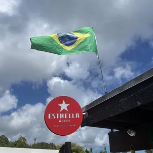 the flag of brazil flying over a gas station