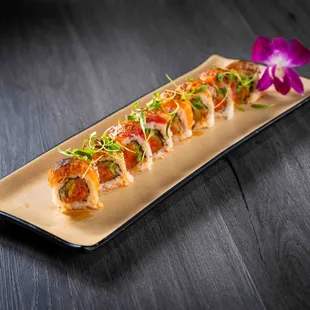 a plate of sushi with a purple flower