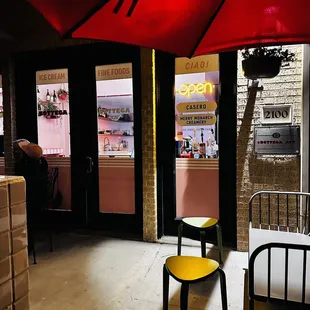 a yellow chair in front of a red umbrella