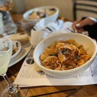 a bowl of pasta and a glass of wine