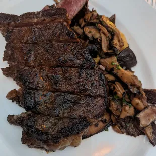 steak, mushrooms, and corn on a white plate