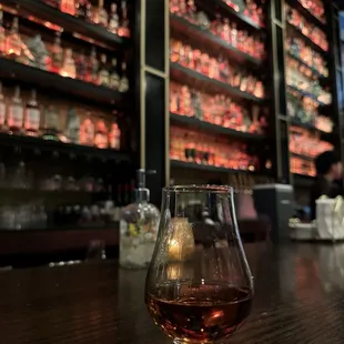 a glass of whiskey on a bar counter