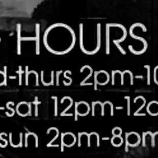 a black and white photo of a hours sign