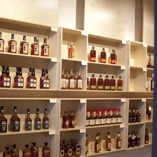 a wall of liquor bottles on shelves
