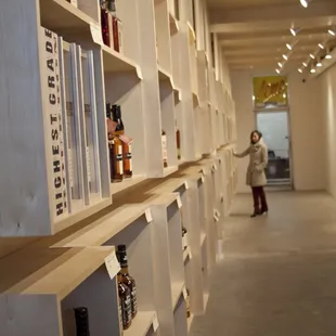 a woman standing in a room with shelves of liquor