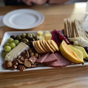 a platter of cheese, crackers, and fruit
