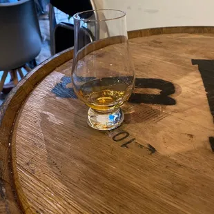 a glass of whiskey on a barrel