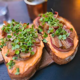 a closeup of a sandwich with bacon and sprouts