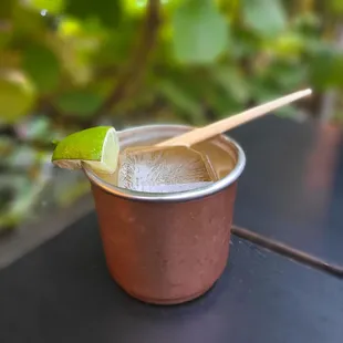 a shot of a drink with a lime wedge