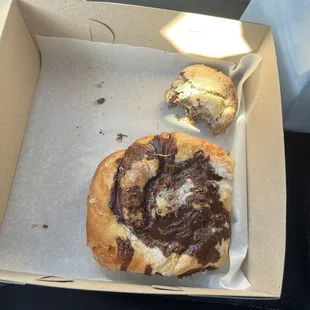 Half eaten cinnamon raisin scone and chocolate danish.
