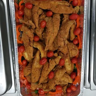 a tray of fried chicken and vegetables