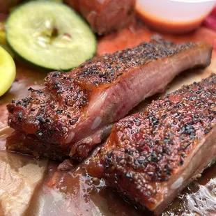a close up of ribs and pickles