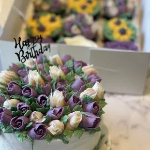 a white cake with purple and yellow flowers