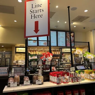 a grocery store with a line starts here sign