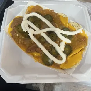 a hot dog in a styrofoam container