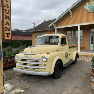 a yellow truck parked in front of a restaurant