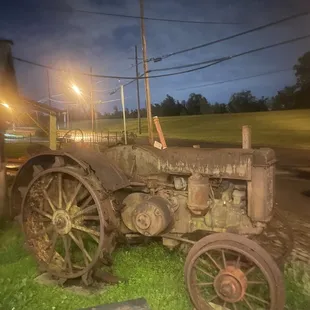 A very very old tractor to the left of the restaurant!