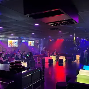 people sitting at tables in a dimly lit room