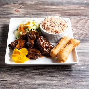 Oxtails served with rice peas steam cabbage plantain &amp; festival