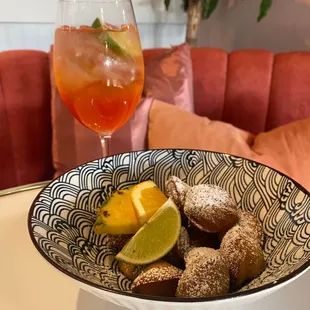 a bowl of donuts and a drink